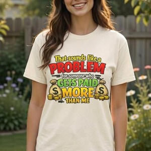 Woman in denim shorts in a garden wearing the "That Sounds Like a Problem for Someone Who Gets Paid More Than Me" sarcastic coworker T-shirt by SarcasmArt in Ivory.
