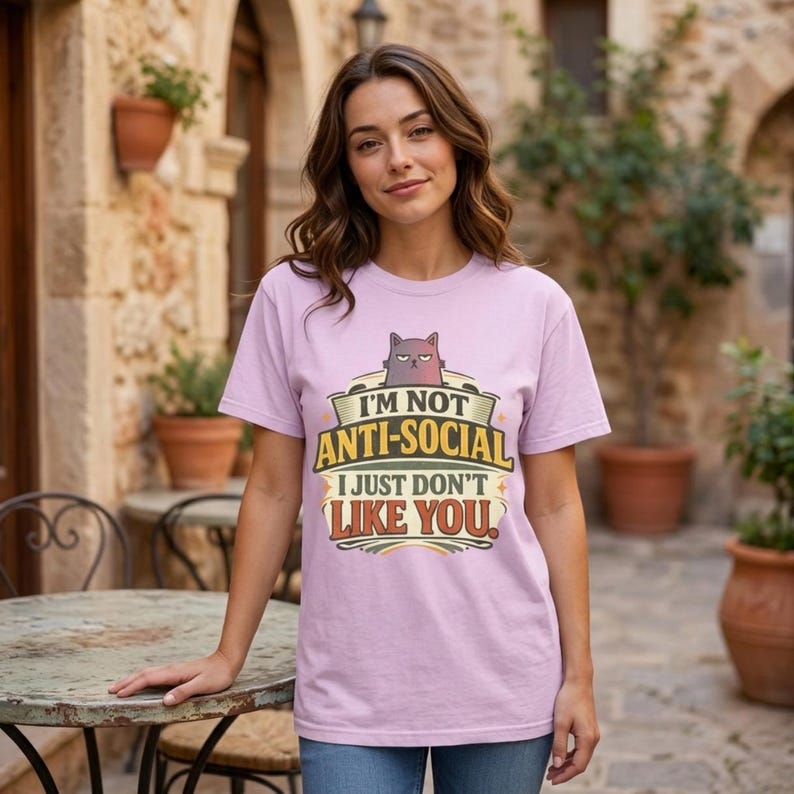 Woman on a terracotta terrace wearing the "I'm Not Anti-Social, I Just Don't Like You" sarcastic introvert T-shirt by SarcasmArt in Orchid (soft lilac).