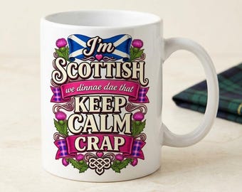 May include: A white ceramic mug featuring a graphic design with a Scottish flag, purple thistle flowers, and pink ribbons. The text reads: I'm SCOTTISH we dinnae dae that KEEP CALM CRAP. The design includes a Celtic knot motif at the bottom.