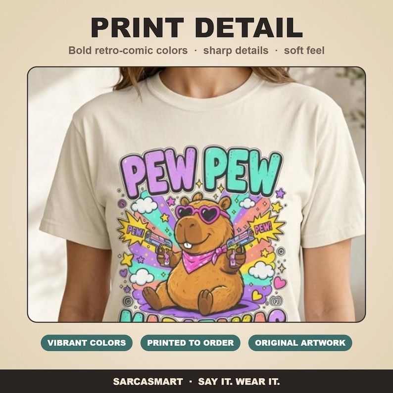 Print detail of the "Pew Pew Madafakas" capybara meme T-shirt by SarcasmArt: bold retro-comic colors, sharp details and a soft feel.