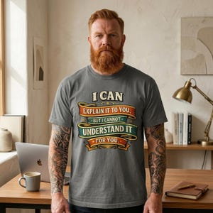 Bearded man in a home office wearing the "I Can Explain It to You, But I Can't Understand It for You" sarcastic teacher T-shirt by SarcasmArt in Pepper.