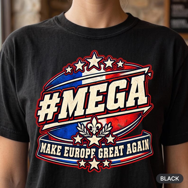 Close-up of the "#MEGA Make Europe Great Again" France T-shirt by SarcasmArt in Black: a retro #MEGA sports badge with the blue-white-red French tricolore, a fleur-de-lis emblem with laurel, stars and a MAKE EUROPE GREAT AGAIN banner, printed large on a garment-dyed Comfort Colors 1717 tee.