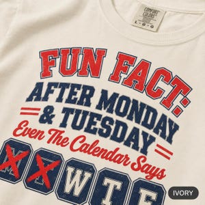 Close-up of the "Fun Fact: After Monday & Tuesday" WTF varsity work T-shirt by SarcasmArt print on Ivory garment-dyed cotton: red and navy varsity lettering reading FUN FACT: AFTER MONDAY & TUESDAY – Even The Calendar Says WTF, with M and T crossed out.