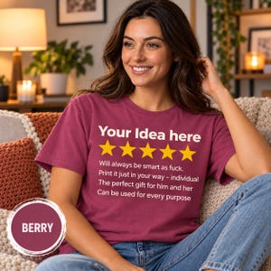 Smiling woman on a sofa wearing the personalized golden 5-star review T-shirt by SarcasmArt in Berry.