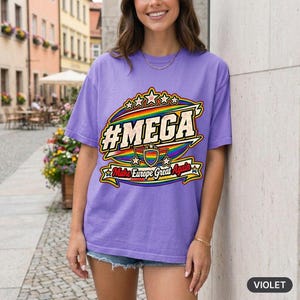 Woman in front of a pastel city wall wearing the "#MEGA Make Europe Great Again" Rainbow Pride T-shirt by SarcasmArt in Violet.