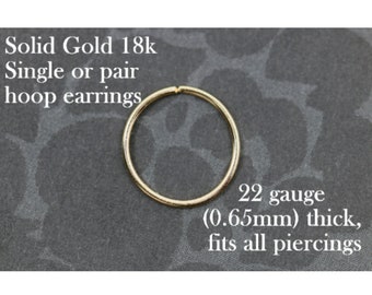 May include: A single gold hoop earring, 22 gauge (0.65mm) thick. Solid gold 18k hoop earrings, single or pair, fits all piercings.