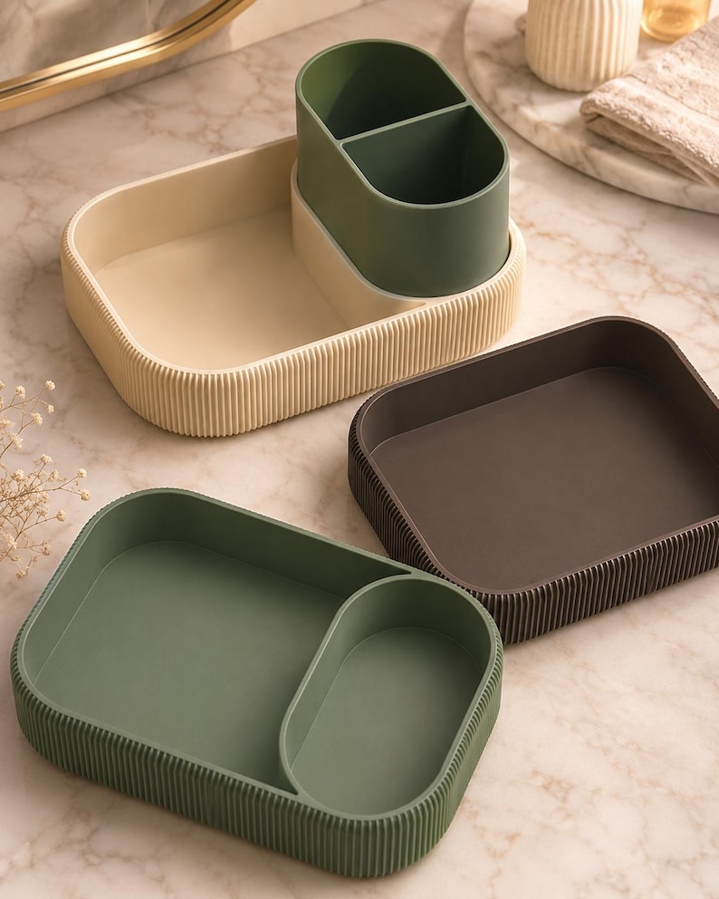 May include: Three rectangular storage organisers with rounded corners and vertical ribbed exterior walls. One organiser is cream with a dark green divided insert, one is dark brown, and one is sage green with a matching divided section.