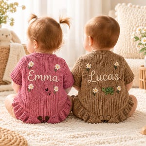 Può includere: Due tutine in maglia indossate da neonati, una rosa polvere e una color cuoio. La tutina rosa presenta il nome ricamato Emma, margherite bianche e una coccinella. La tutina color cuoio presenta il nome Lucas, margherite bianche e una tartaruga.