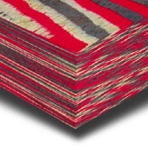 May include: A stack of folded textiles featuring a bold striped design in red, grey, and cream. The fabric has a woven texture. The edges are precisely aligned, forming a neat, geometric shape. The colour palette is striking.