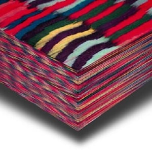 May include: A stack of patterned fabric with a colourful, abstract design. The top layer has bold, brushstroke-like stripes in red, blue, green, yellow, and purple. The edges of the fabric are a mix of red, pink, and other colours.
