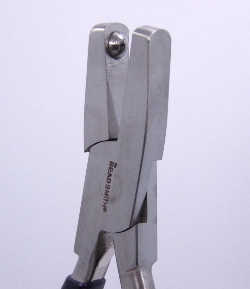 May include: Close-up of a silver beadsmith pliers with a rounded tip. The pliers are designed for crimping beads and have a logo that reads "Beadsmith".