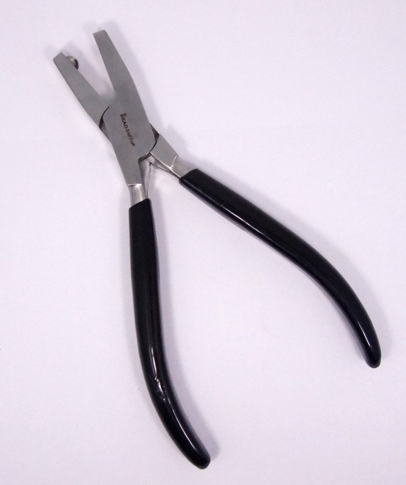 May include: Black handled pliers with silver jaws for crimping jewelry findings. The pliers have the text "Beadsmith" printed on the side.