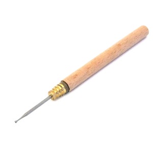May include: A wooden handled tool with a metal tip, used for crafting and beading.