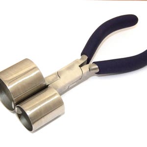 May include: A pair of silver-toned jewelry pliers with blue rubber handles. The pliers have two round, hollow jaws.