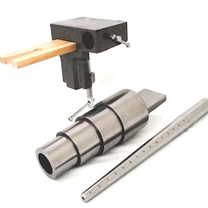 Peut inclure: Un ensemble de mandrins à anneaux en métal pour le dimensionnement des anneaux, un calibreur d'anneaux en métal et une pince à anneaux en bois avec une base en métal noir.