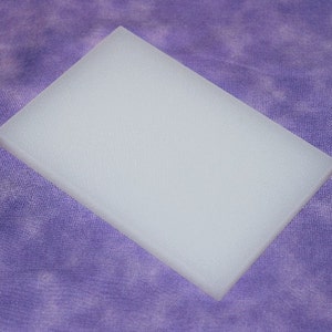May include: A white, rectangular, frosted acrylic sheet.