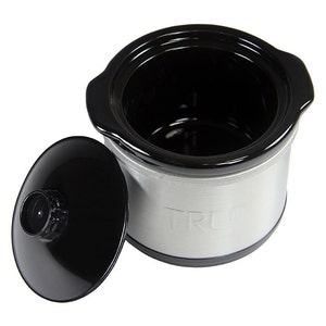 May include: A small, silver slow cooker with a black ceramic pot and a black lid. The slow cooker has the word "TRU" embossed on the side.