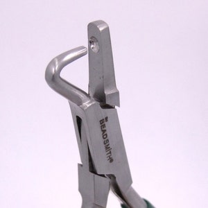 Könnte beinhalten: Nahaufnahme einer silberfarbenen Schmuckzange mit einem gebogenen und einem geraden Kiefer. Die Zange ist mit "Beadsmith" beschriftet.