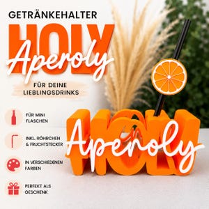 Könnte beinhalten: Ein orangefarbener Getränkehalter mit dem Schriftzug "HOLY Aperoly" in Block- und Schreibschrift. Der Halter enthält einen schwarzen Strohhalm mit einer orangen Scheibe als Dekoration. Der Text lautet "GETRÄNKEHALTER HOLY Aperoly FÜR DEINE LIEBLINGSDRINKS" mit Symbolen für Miniflaschen, Röhrchen, Fruchtstecker, Farben und Geschenke.