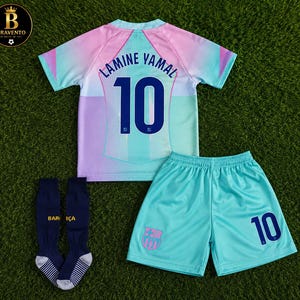 May include: A football kit comprising a jersey, shorts, and socks. The jersey has a pastel gradient of pink, blue, and white, displaying the name LAMINE YAMAL and the number 10 in dark blue. The shorts are light blue with the number 10 and a team crest.