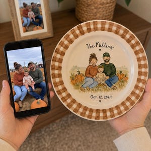May include: A round ceramic plate with a brown and white gingham border featuring a hand-painted illustration of a family of three sitting in a pumpkin patch. The text reads The Millers and Oct. 12, 2024, with small heart icons above and below.