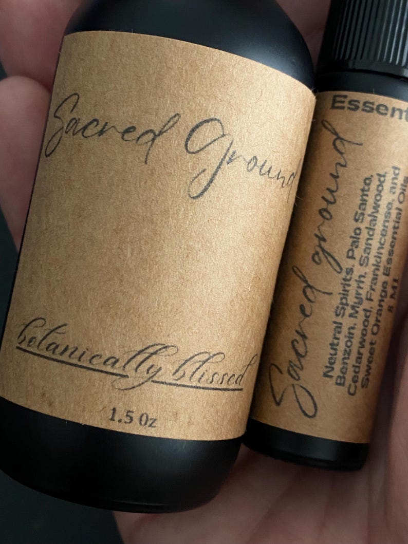Pode incluir: Duas garrafas pretas de &oacute;leo essencial com r&oacute;tulos castanhos. Os r&oacute;tulos dizem "Sacred Ground" e "Botanically Blissed". Uma garrafa &eacute; rotulada 1,5 oz. A outra garrafa lista &oacute;leos essenciais.