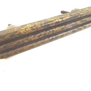 May include: A weathered, rectangular drawer pull with a layered design. The hardware features a mottled brown and gold finish, suggesting an antique or vintage aesthetic. The pull has a small, rounded handle.