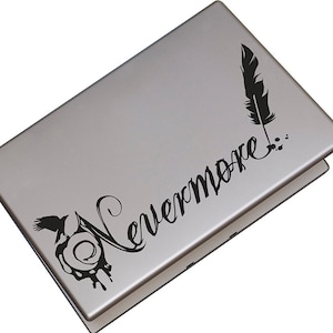 May include: A silver laptop with a black vinyl decal featuring a raven, a feather, and the text "Nevermore."