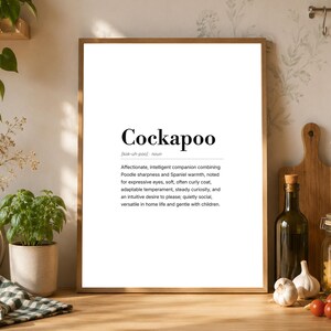 Puede incluir: Un cuadro rectangular con una lámina que muestra la palabra Cockapoo en una fuente serif negra en negrita, seguida de una pronunciación fonética y una definición estilo diccionario que describe los rasgos de la raza canina en texto negro sobre fondo blanco.