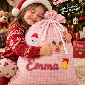 May include: A pink and white gingham Christmas gift sack featuring a white rope drawstring, a Santa Claus patch, a reindeer patch, a yellow bell patch, and the name Emma embroidered in pink. Text reads A Special Gift for Someone Special.