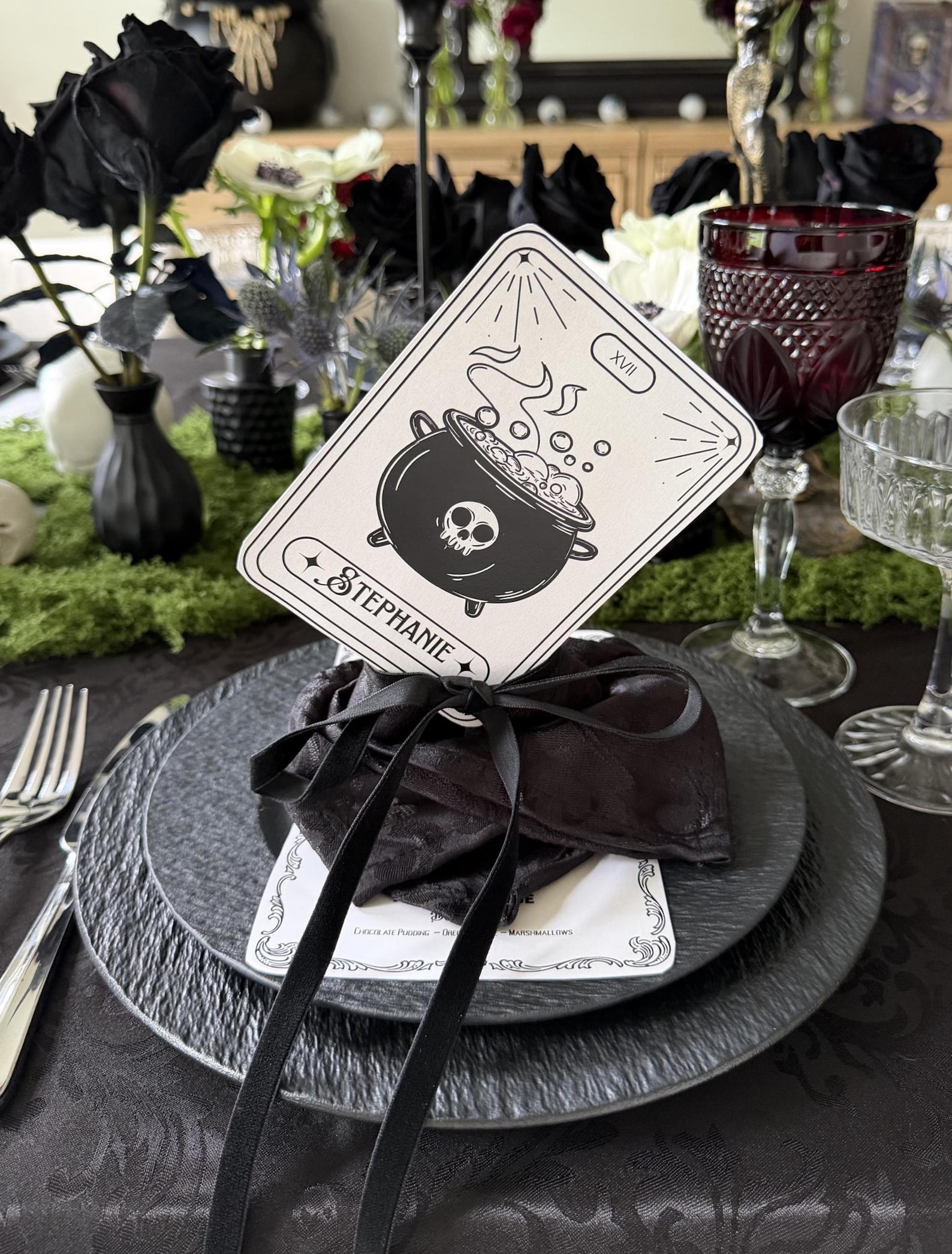 A Tarot-Style Card for a Witches’ Table Tarot-inspired Halloween place card displayed on a dark plate setting.