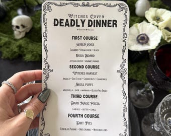 May include: A rectangular white menu card with black decorative borders and text titled Witches Coven Deadly Dinner. The menu lists four courses including Goblin Eyes, Ouija Board, Witches Harvest, Skull Puffs, Dark Magic Pasta, and Dirt Pies.