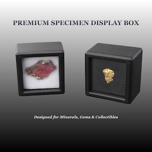 May include: Two square black display boxes labeled PREMIUM SPECIMEN DISPLAY BOX and Designed for Minerals, Gems & Collectibles. One box contains a red iridescent mineral specimen on white padding, and the other holds a gold nugget on black padding.