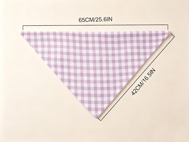 May include: A triangular bandana featuring a light purple and white gingham check pattern. The fabric accessory measures 25.6 inches along the top edge and 16.5 inches along the side edge as indicated by the printed dimension lines.