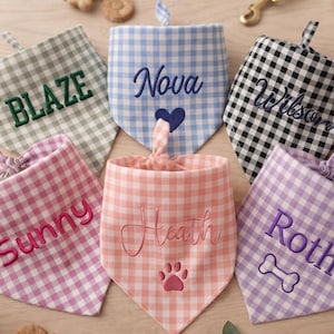 May include: A collection of six triangular pet bandanas featuring gingham patterns in sage green, light blue, black, pink, peach, and lavender. Each bandana is embroidered with a name and a symbol, including Blaze, Nova, Wilson, Sunny, Heath, and Roth.