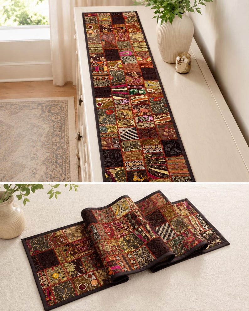 May include: A rectangular table runner featuring a patchwork design composed of numerous small, square fabric panels. The runner displays a variety of intricate patterns, metallic threads, and deep colours including red, gold, and black.