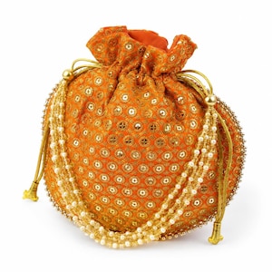 May include: A bright orange drawstring pouch featuring an all-over pattern of small gold sequins and metallic embroidery. The bag is cinched with gold cords and decorated with long, dangling strands of white faux pearls on both sides.