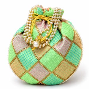 May include: A round drawstring pouch featuring a checkered pattern in shades of lime green, peach, and pink. The fabric has a textured grid design outlined with gold metallic thread. A double-strand pearl handle and yellow cord closure complete it.