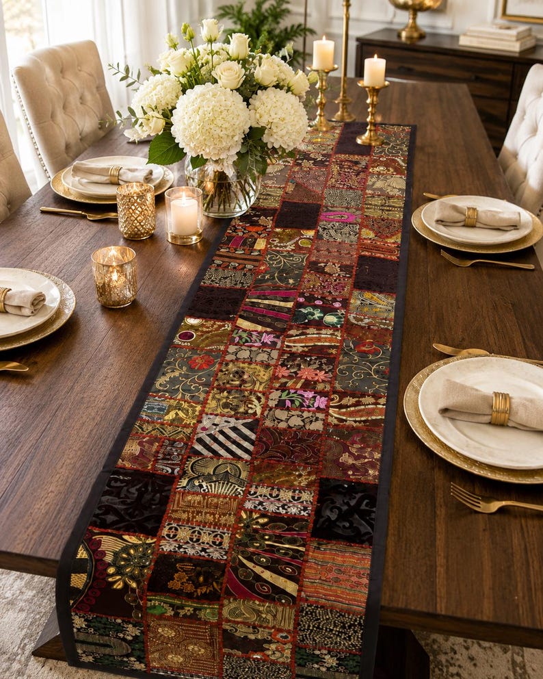 May include: A long rectangular table runner featuring a patchwork design of various fabric squares in dark tones of burgundy, gold, black, and green. The runner displays intricate embroidered patterns, metallic threads, and sequins throughout the surface.