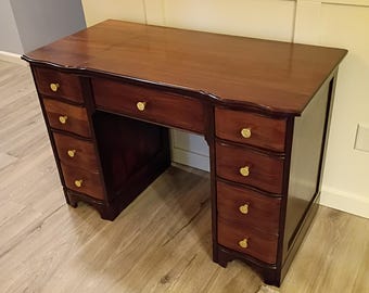 Escritorio antiguo con hueco para las rodillas y silla.