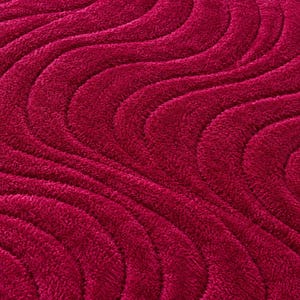 May include: A deep magenta rug featuring a textured, high-pile surface with a repeating pattern of raised, undulating wave lines that create a rhythmic, flowing visual effect across the entire fabric surface of the floor covering.