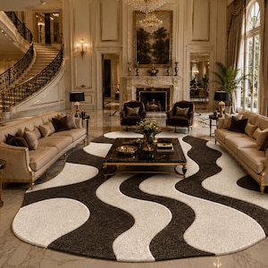 May include: A large oval area rug featuring a bold, repeating wave pattern in contrasting black and cream colors. The rug is positioned in the center of a room, with a black coffee table placed on top of it, surrounded by two beige sofas and chairs.