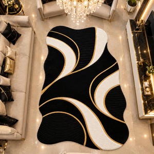 May include: An area rug with an irregular, organic shape featuring a black, white, and gold color palette. The design consists of sweeping, curved lines and textured black sections that contrast with smooth white curves and thin gold accents.