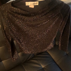 May include: A black sparkly long-sleeved top with a cowl neck. The top has a "New York & Company" label.