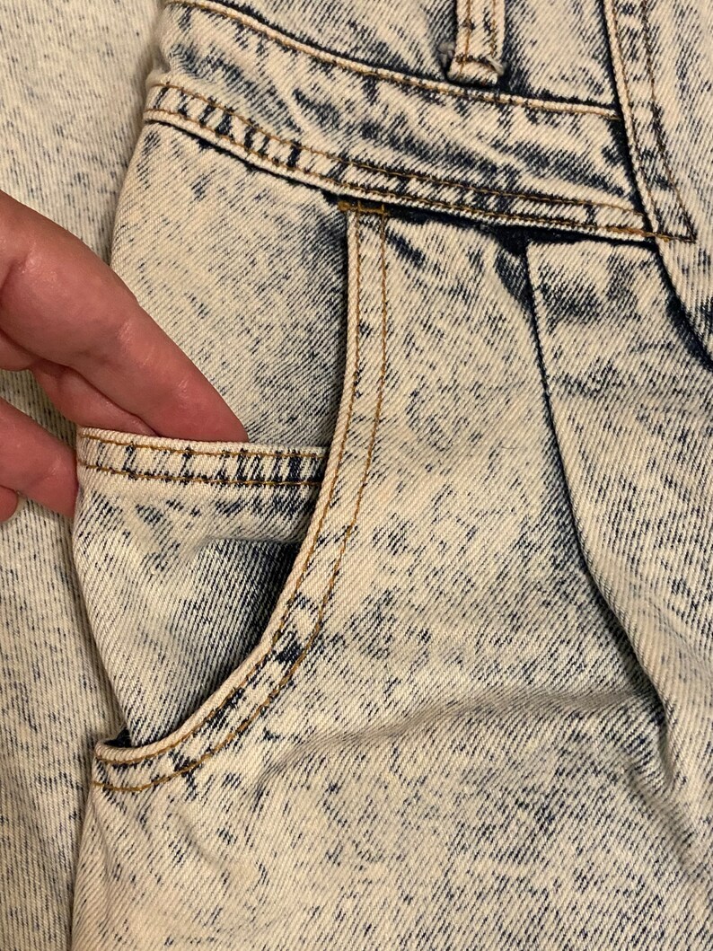 K&ouml;nnte beinhalten: Nahaufnahme einer hellblauen Jeans-Tasche an einer S&auml;ure-Wasch-Jeans. Die Tasche hat einen hellbraunen Stich an den R&auml;ndern.