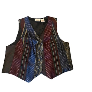 May include: A multi-colored vest made from different patterned fabrics. The vest has a dark brown background with stripes of burgundy, blue, and gold. The vest has a V-neck and a button closure.