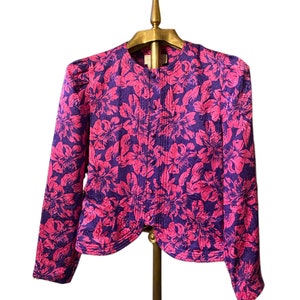 Könnte beinhalten: Eine Bluse mit langem Arm in einem floralen Muster in Lila und Pink mit Knopfleiste.