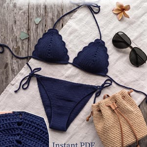 May include: A navy blue crochet bikini set featuring a scalloped edge on the triangle top and tie-side bottoms. The image includes the text Crochet Bikini Pattern and Instant PDF Download, alongside a beige woven drawstring bag and sunglasses.