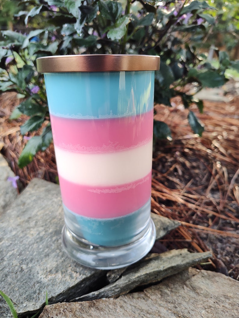 May include: A layered candle in a clear glass jar with a copper lid. The candle is blue, pink, and white.