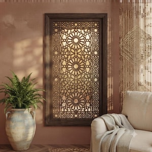 Peut inclure: Un panneau mural rectangulaire doté d'un cadre en bois brun foncé et d'un motif géométrique complexe découpé au laser, composé d'étoiles et de cercles répétitifs. Le panneau est fixé sur une surface murale unie de couleur terre cuite.
